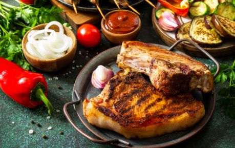 Pork Chops on plate surrounded by vegetables 